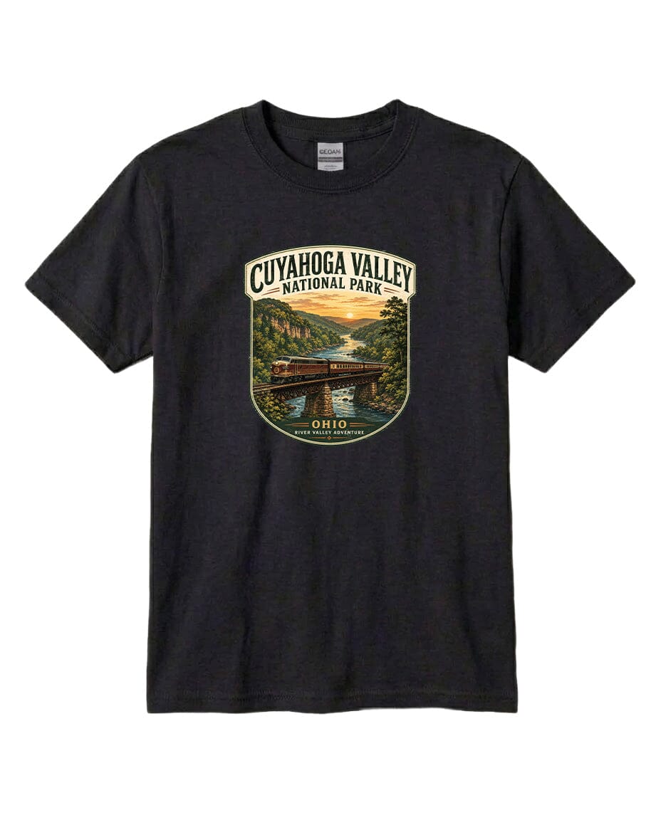 A black t-shirt with a graphic design depicting a scenic view of the Cuyaohoga Valley National Park, featuring a bridge, trees, and a sunset over a river.