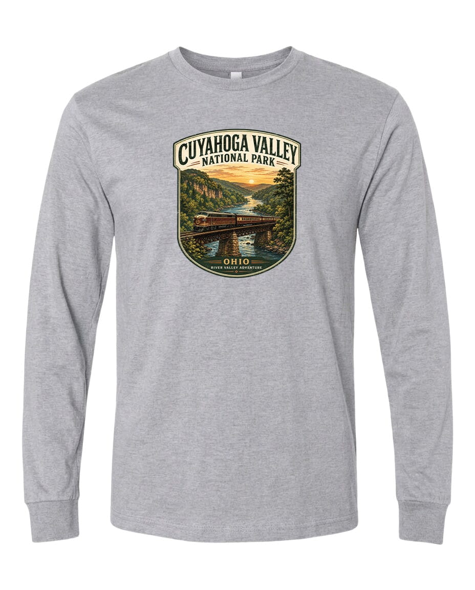 A gray long-sleeved t-shirt with a graphic design depicting a scenic view of the Cuyaohoga Valley National Park, featuring a bridge, trees, and a sunset over a river.