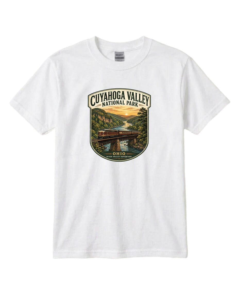 A white t-shirt with a graphic design depicting a scenic view of the Cuyaohoga Valley National Park, featuring a bridge, a river, and a sunset.