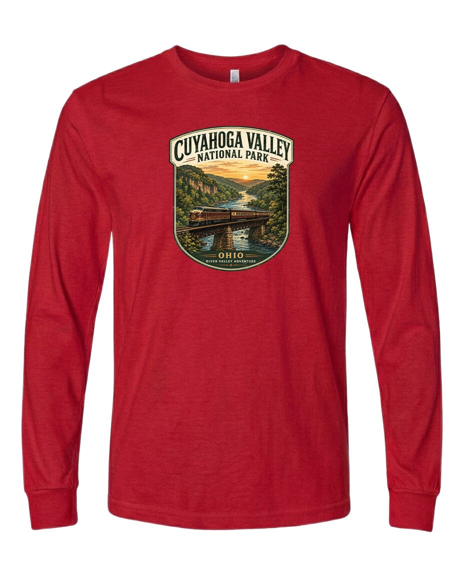 A red long-sleeved t-shirt with a graphic design depicting a scenic view of the Cuyaohoga Valley National Park, featuring a bridge, trees, and a sunset.