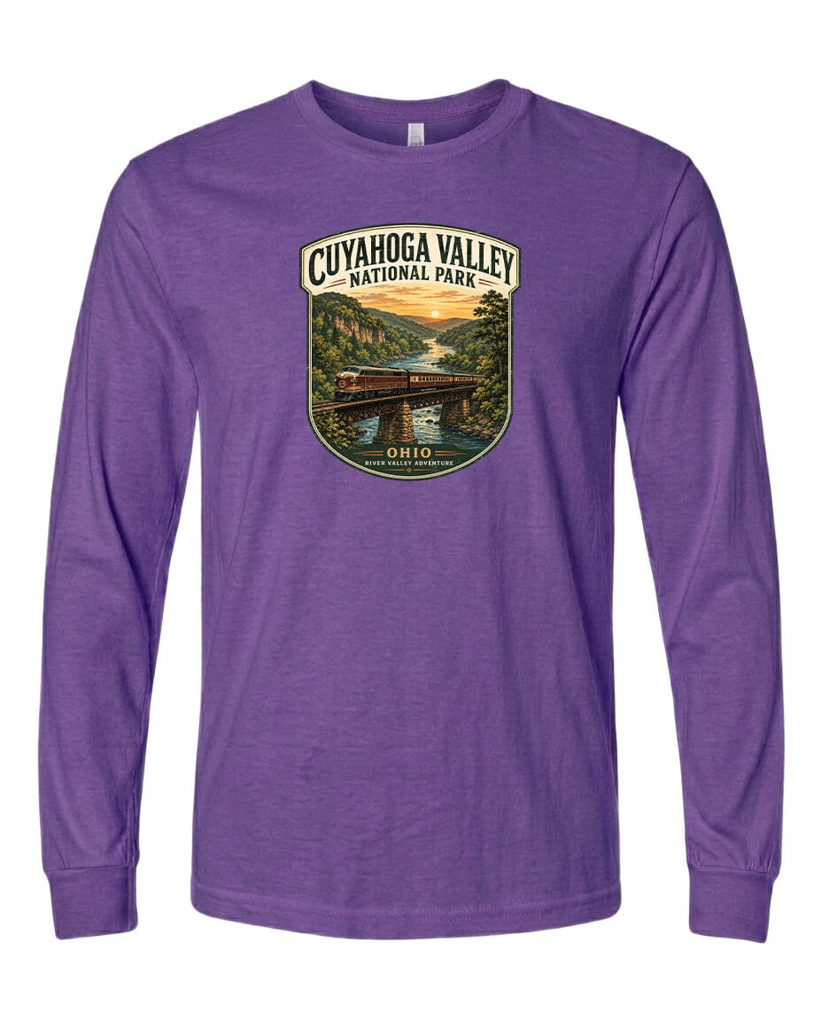 A purple long-sleeved t-shirt with a graphic design depicting a scenic view of the Cuyahogah Valley National Park, featuring a bridge, trees, and a sunset.