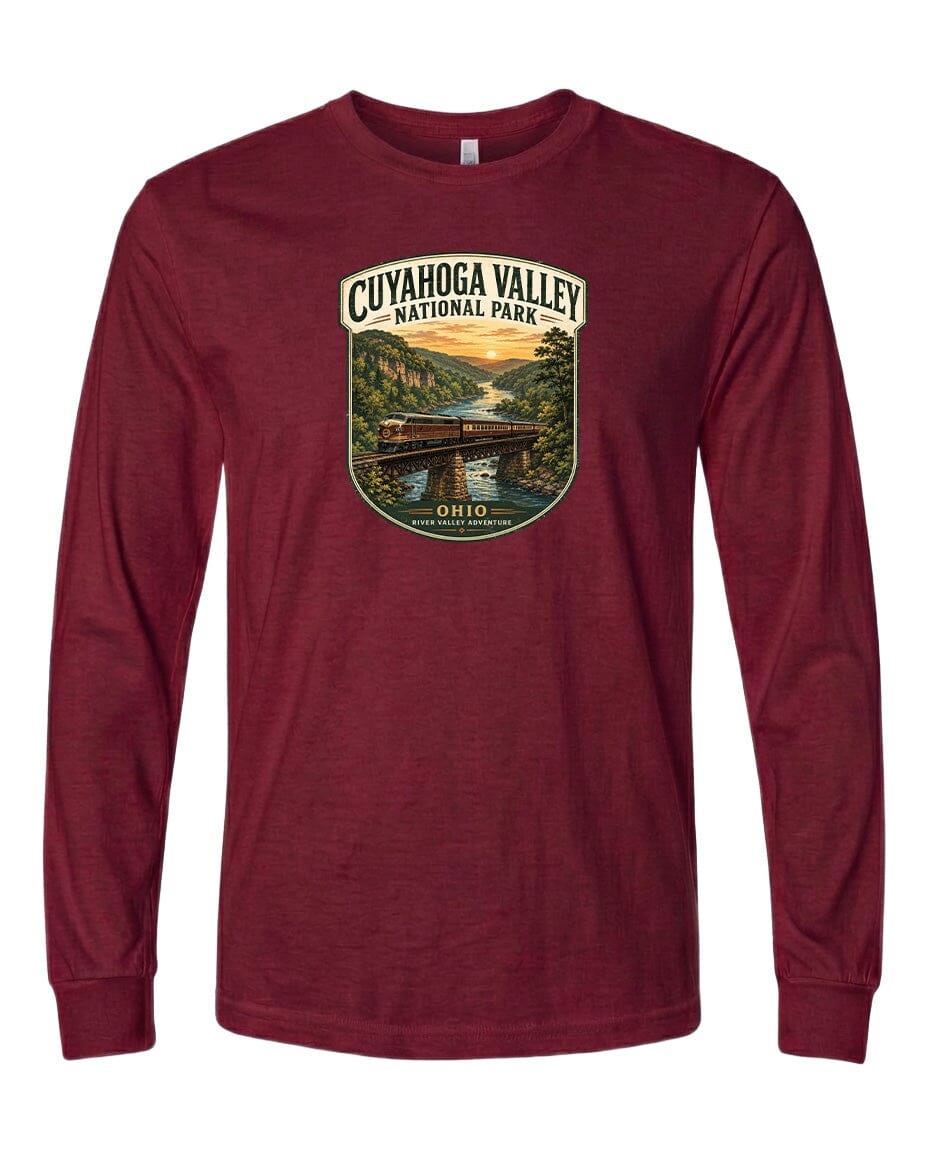 A red long-sleeved t-shirt with a graphic design depicting a scenic view of the Cuyahogah Valley National Park, featuring a bridge, trees, and a sunset over a river.