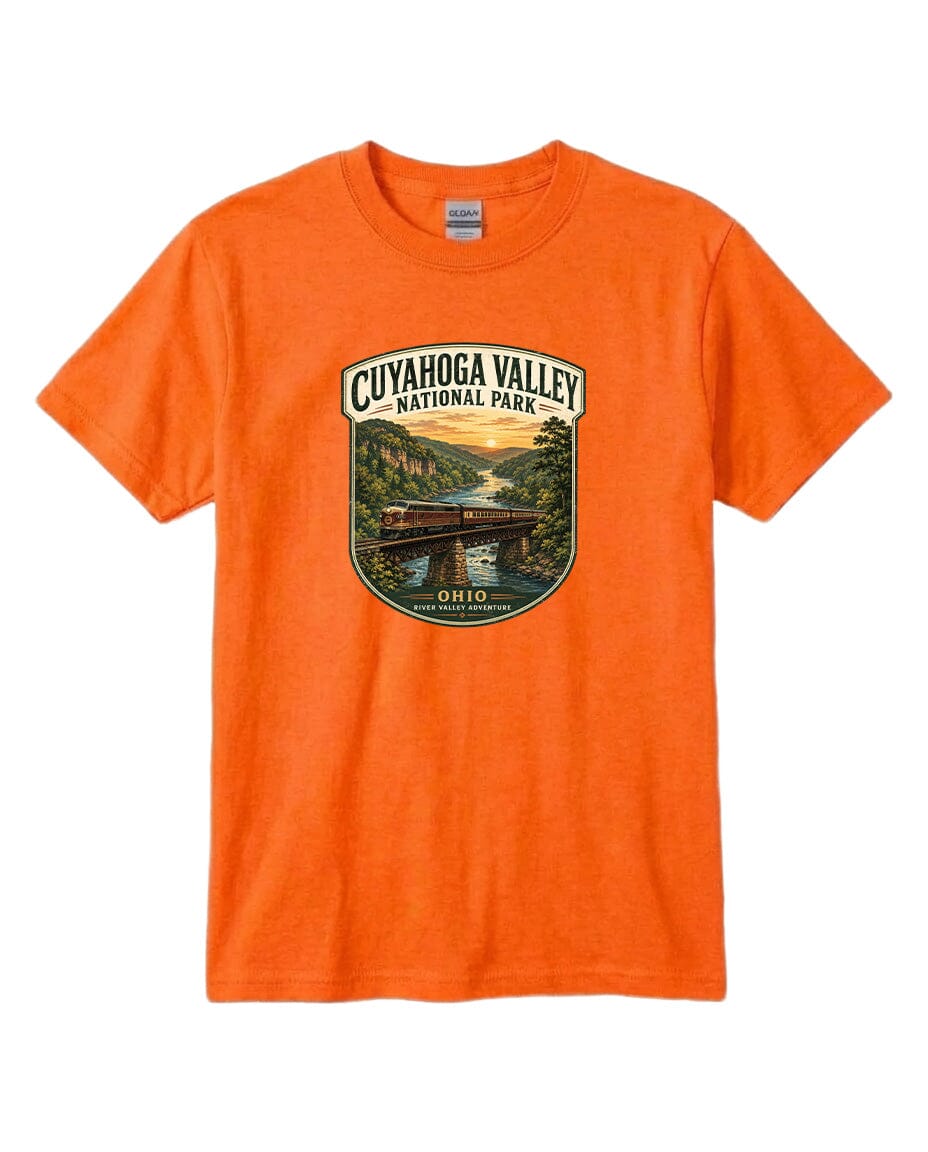 An orange t-shirt with a graphic design depicting a scenic view of the Cuyaohoga Valley National Park, featuring a bridge and a river.