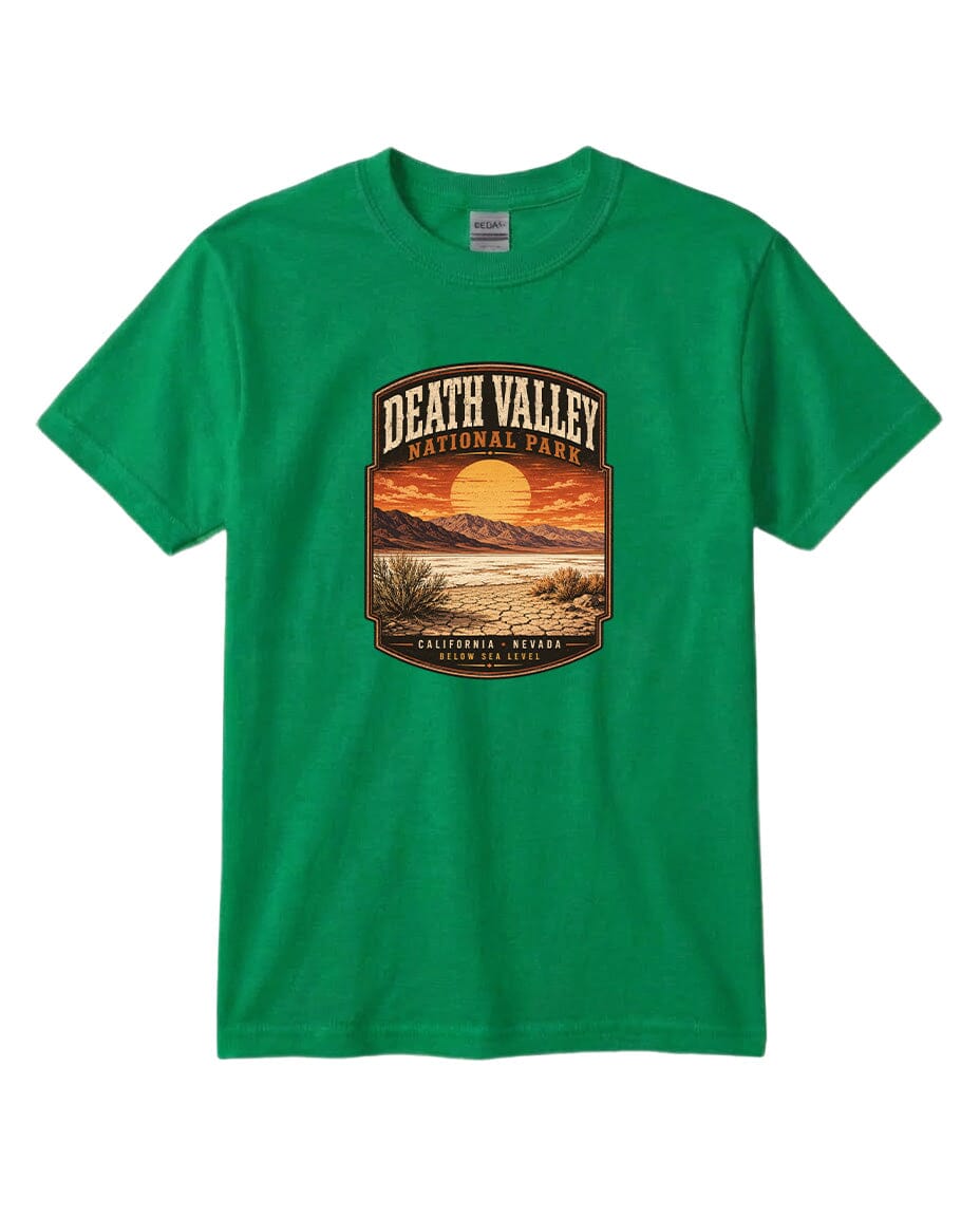 A green t-shirt with a graphic design depicting a scenic landscape with a sunset, mountains, and desert vegetation.