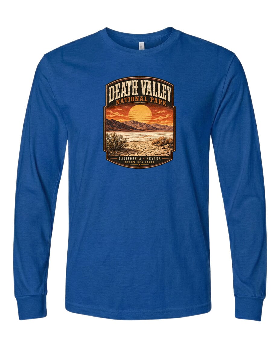 A blue long-sleeved t-shirt with a graphic design depicting a desert landscape with a sunset and mountains in the background.
