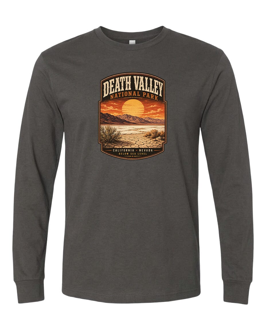 A long-sleeved gray t-shirt with a graphic design depicting a desert landscape with a sunset and mountains in the background.