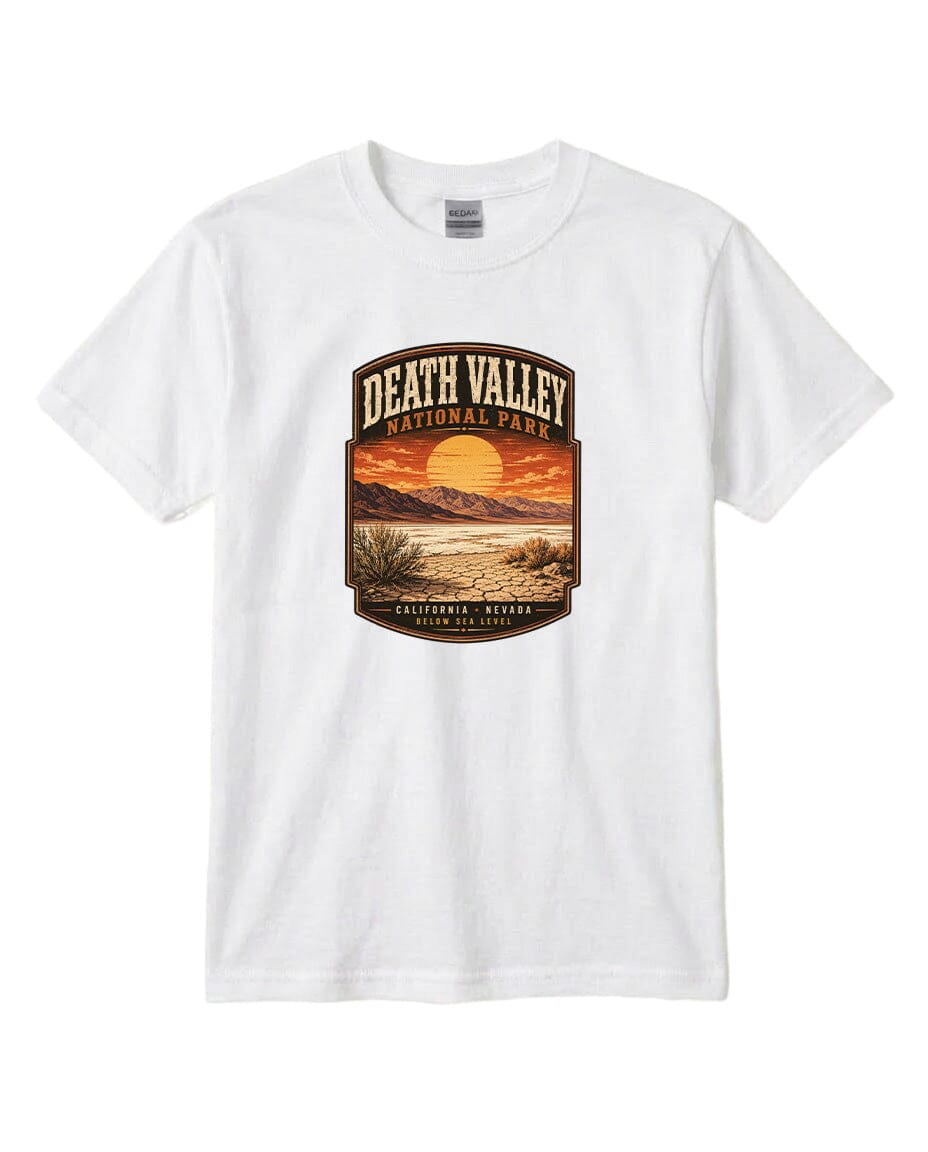 A white t-shirt with a graphic design depicting a scenic landscape with a sunset, mountains, and desert vegetation.