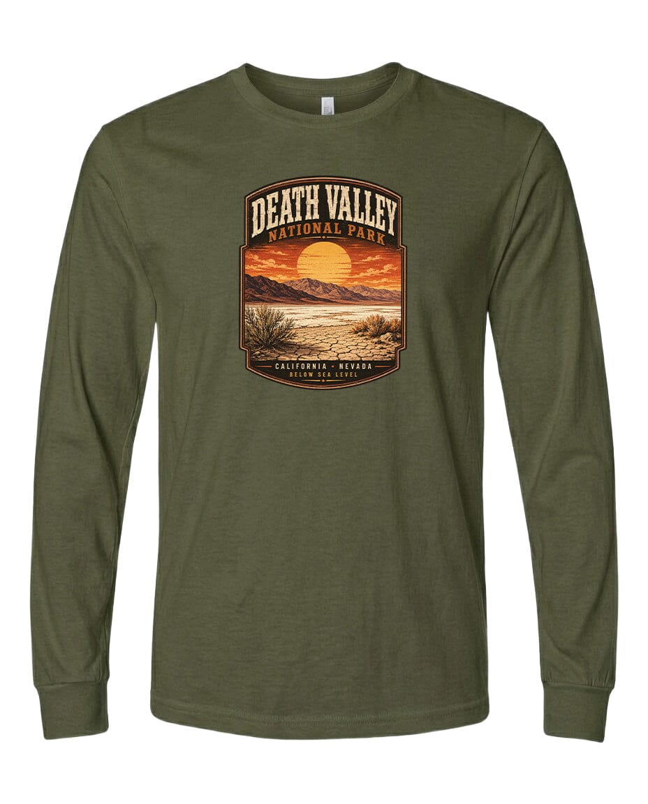 A long-sleeved olive green t-shirt with a graphic design depicting a desert landscape with a sunset and mountains in the background.
