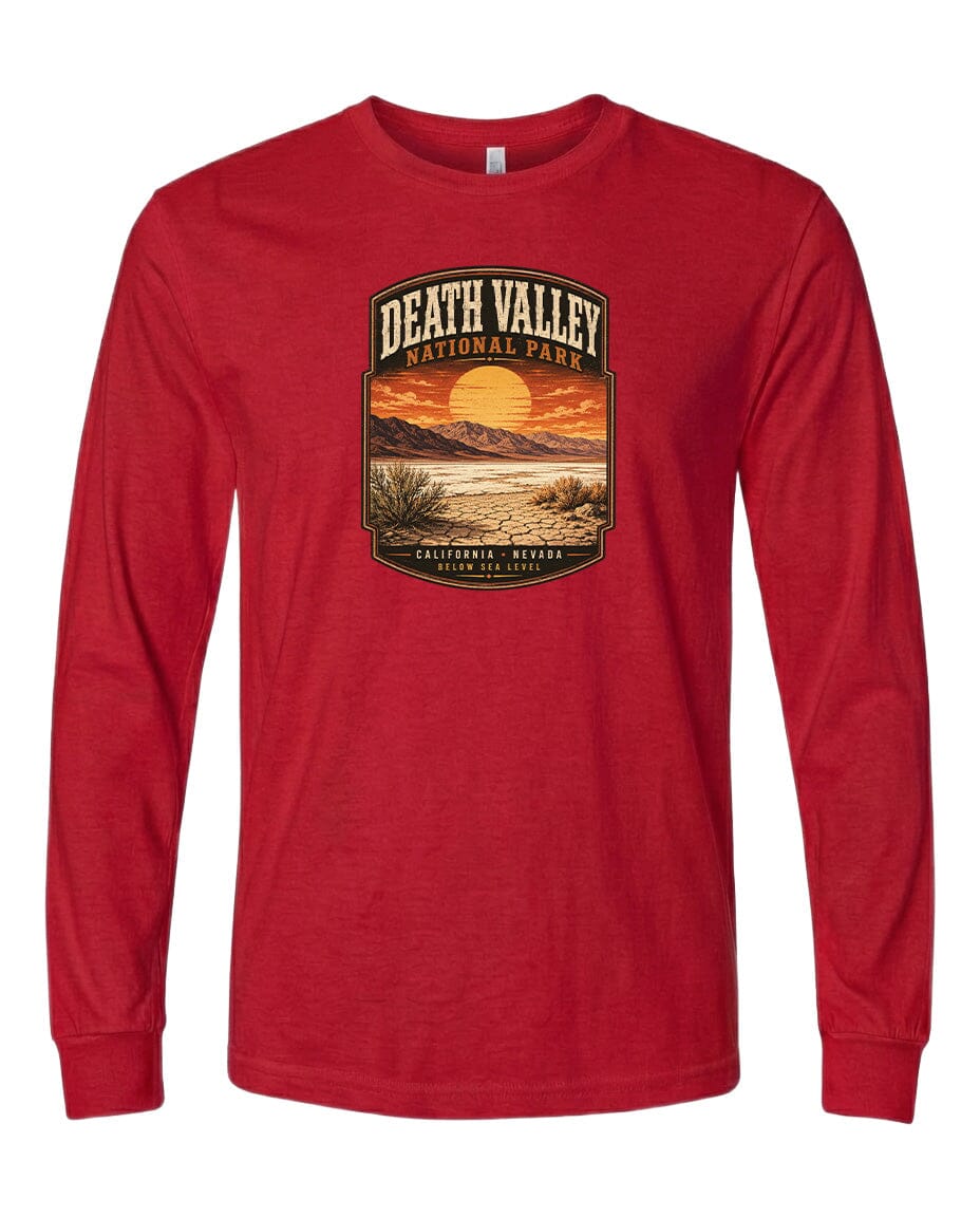 A red long-sleeved t-shirt with a graphic design depicting a desert landscape with a sunset and mountains in the background.