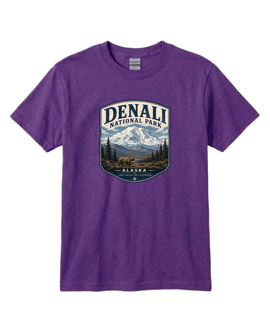 A purple t-shirt with a graphic design depicting a mountain landscape and bears, along with the text "DENALI NATIONAL PARK ALASKA LAST GREAT WILDERNESS".