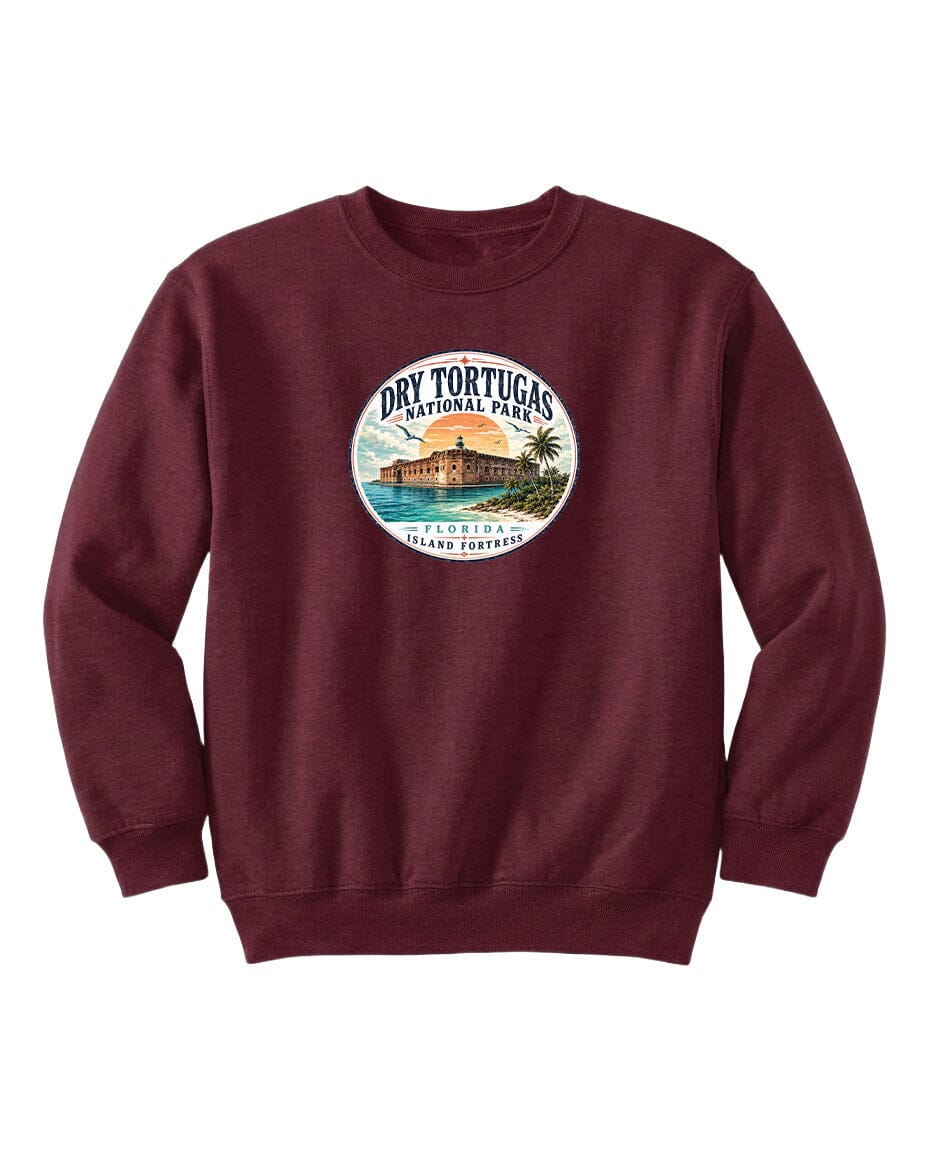 A burgundy-colored sweatshirt with a circular design featuring a beach scene and a building, likely representing Dry Tortugas National Park in Florida.