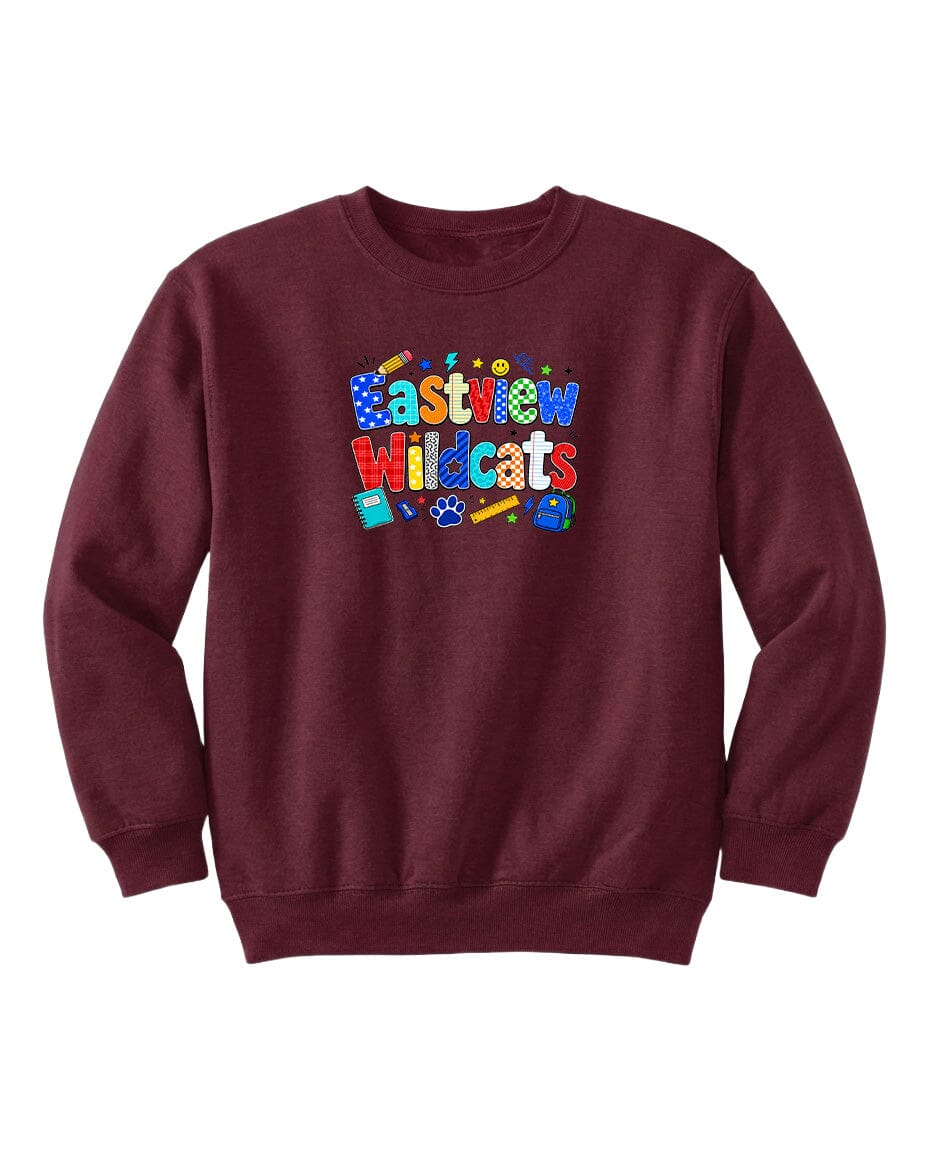 A burgundy sweatshirt with a colorful graphic design featuring the text "Eastview Wildcats" and various school supplies such as pencils, backpacks, and a calculator.