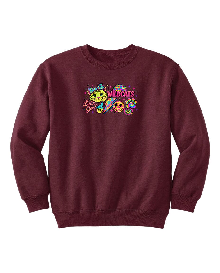 A burgundy sweatshirt with a colorful graphic design featuring a smiling face, a cat, and the text "WILDCATS" along with a smiley face.